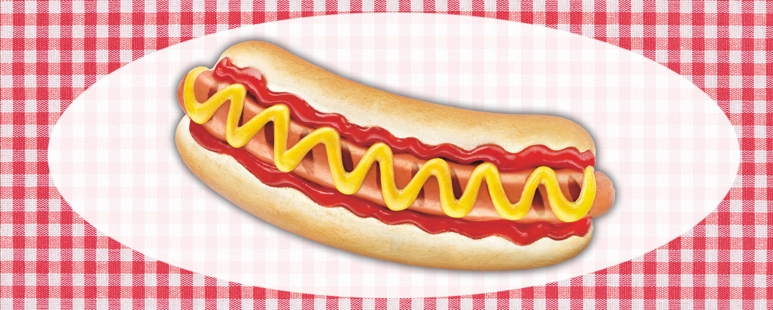 a hot dog with ketchup and mustard on a picnic background