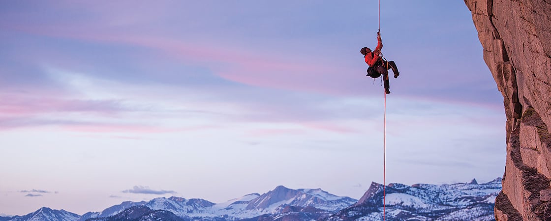 Photo of a rock climber scaling a mountain