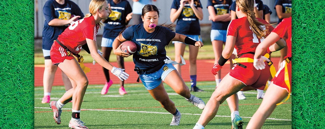 A Marina High School flag football player runs with the ball as defenders close in