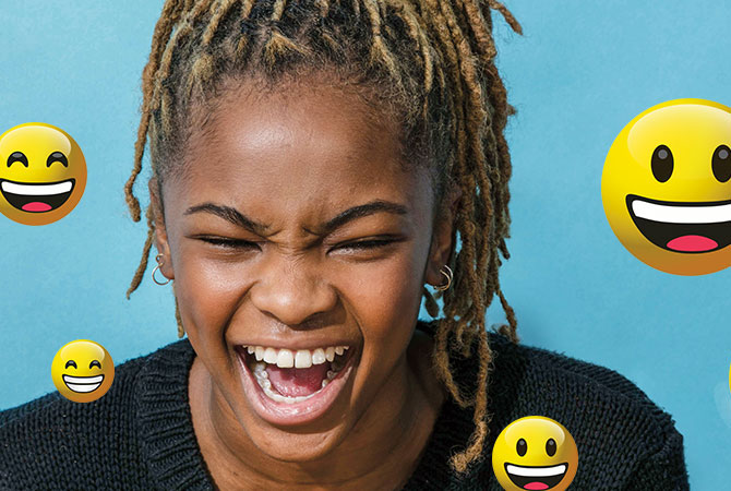 Girl laughing with emojis around her