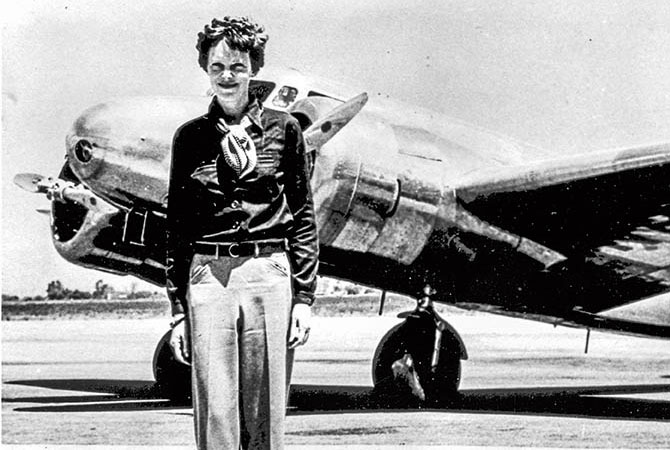 Amelia Earhart next to her airplane